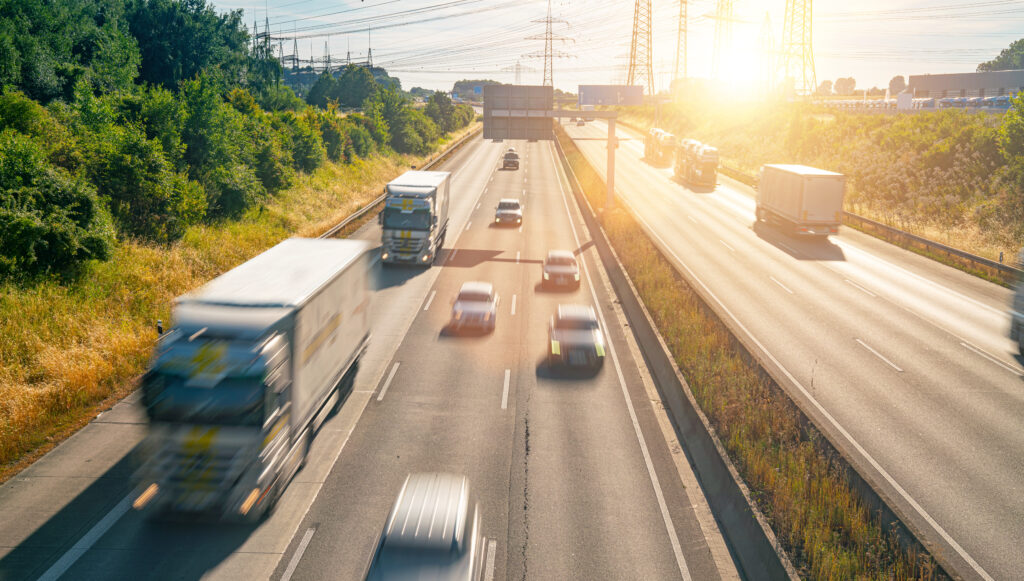 Snelle container trucks op de snelweg met groene bosrijke omgeving en heldere zonsondergang, logistiek en transport voor zakelijke levering, efficient vrachtvervoer, verkeersdrukte.