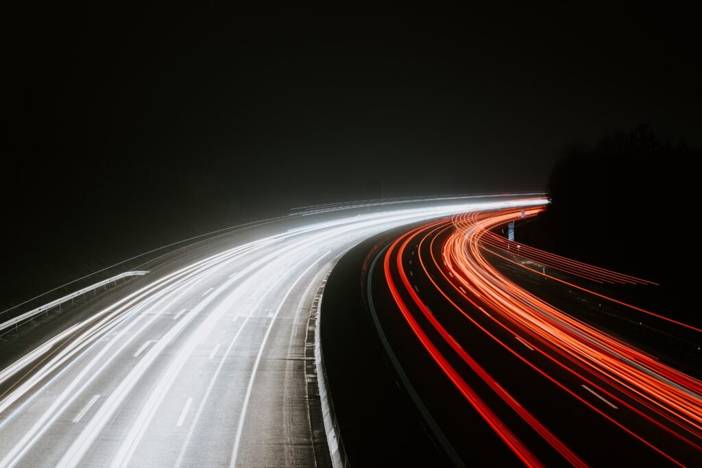 Lichtstraten op snelweg bij nacht, lange belichting, verkeer en snelheid, autosnelweg verlichting, auto lichtsporen, snelwegrijden, dynamische mobiliteit, verkeersveiligheid, wegverlichting, logistiek en transport, moderne infrastructuur.