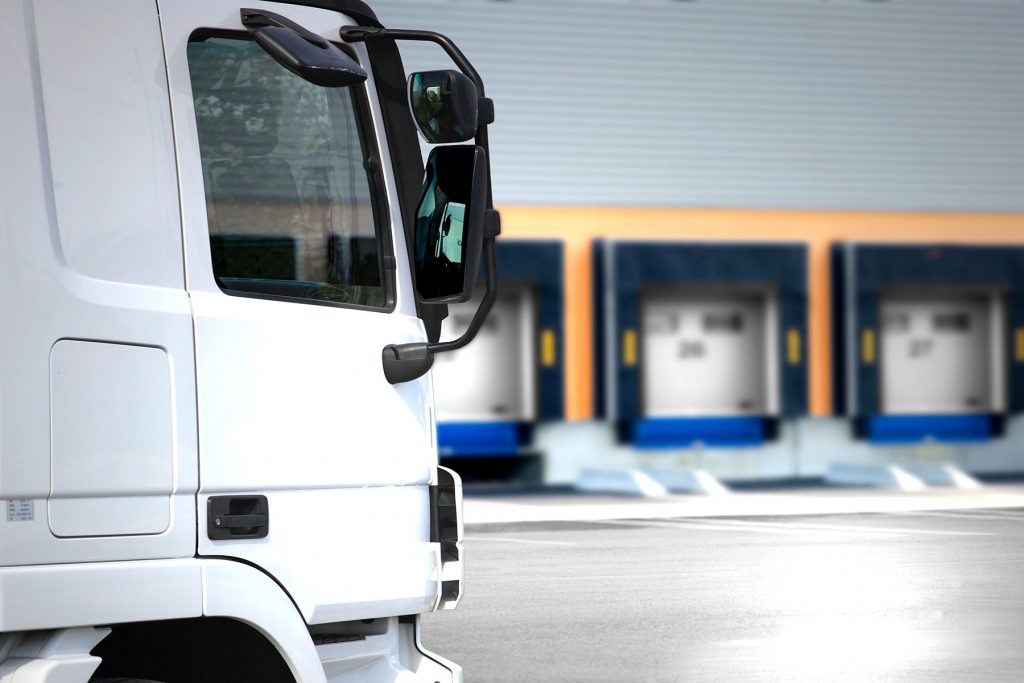 Logitrans vrachtwagen bij logistieke distributiehal, levering en transport services, professionele logistiek, voorraadbeheer, supply chain oplossingen, logistieke dienstverlening Nederland.