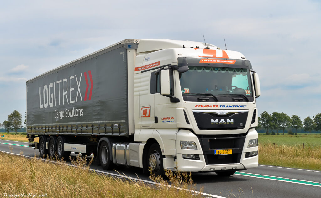 Man truck met LOGITREX Cargo Solutions logo op de zijwand, rijdend op snelweg in open landschap met groene velden en bomen, professionele logistieke vervoersoplossingen, transportation, vrachtwagen, big cargo truck, transportbedrijf.