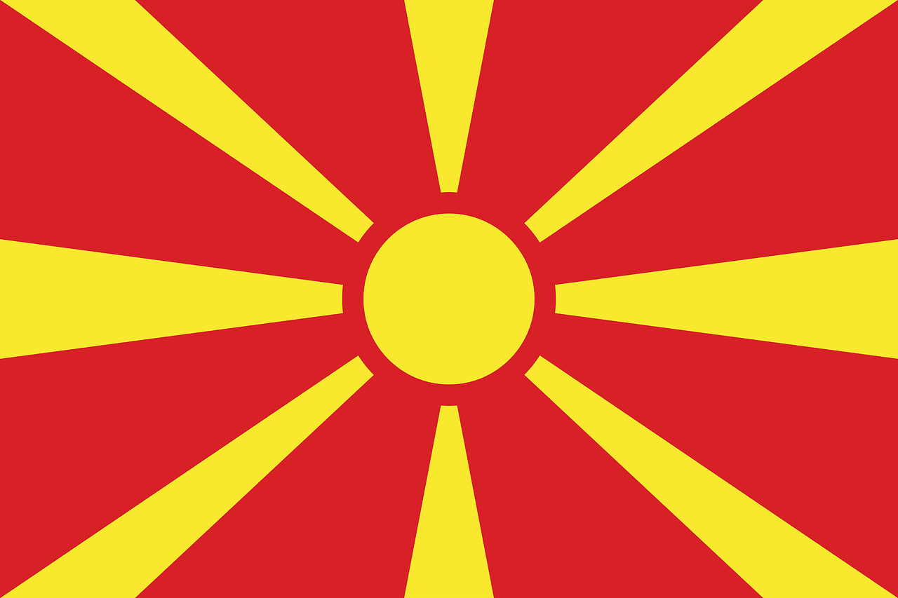 Vlag van Noord-Macedonië met rood en geel ontwerpaal met stralen vanuit het centrum.